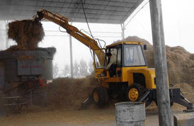 Cargador frontal de ruedas con pinza para hierba